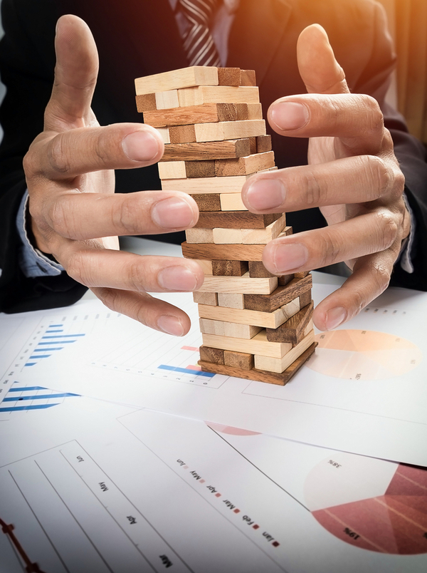 Professional balancing wooden blocks on business charts representing engineering challenges